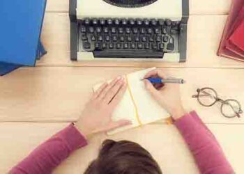 Girl typing on the old typewriter.