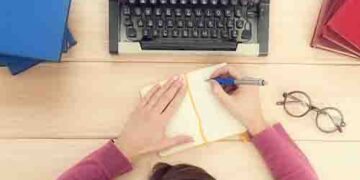 Girl typing on the old typewriter.